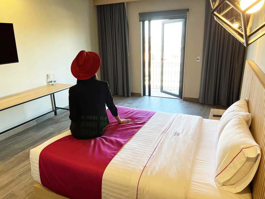 Clara sitting on a bed in Hotel MX Pool