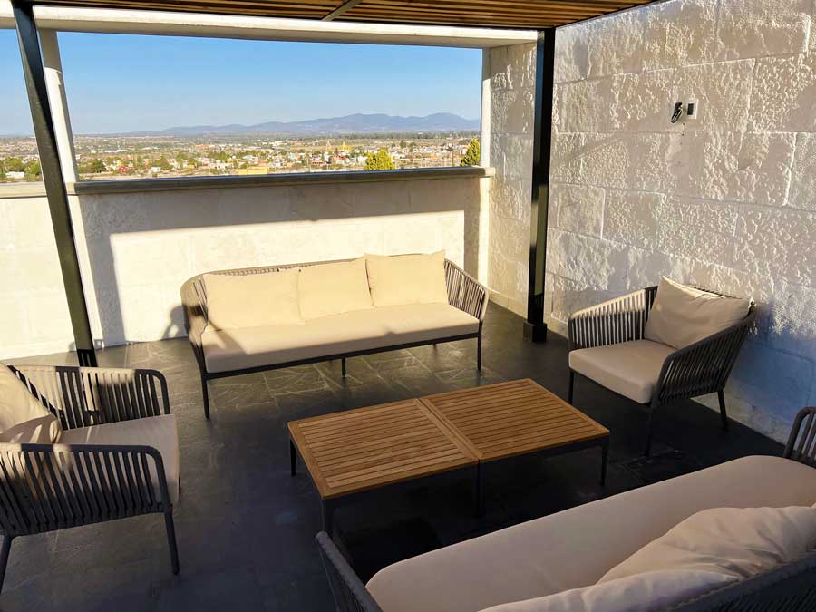 View of table and couches on the rooftop in Hotel MX