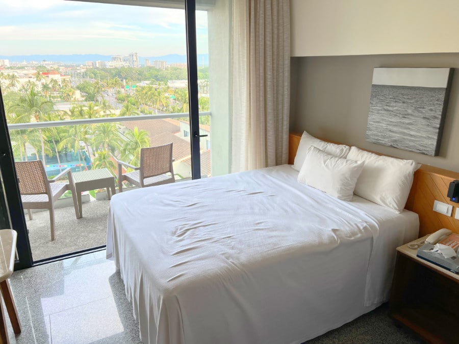 View of the bed and the balcony in Hotel Mio Vallarta