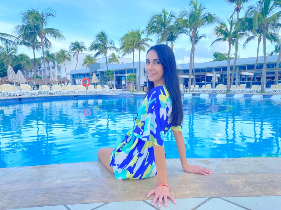 Clara sitting near the pool in Hotel Riu Yucatan
