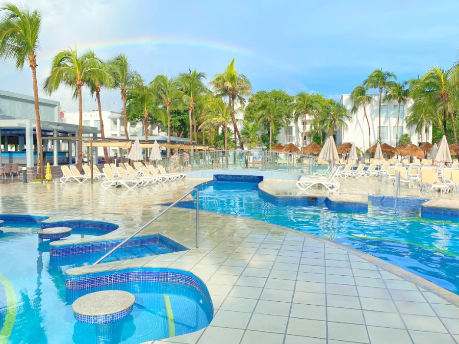 The Hotel Riu Yucatan Pools and the visible rainbow on the clear blue sky
