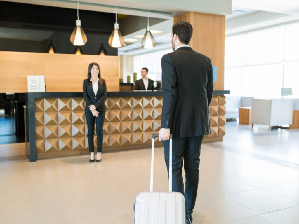 A staff welcoming a guest on a hotel