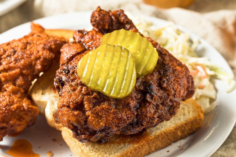 Deep fried chickens with toasted bread, coleslaw and sliced pickles
