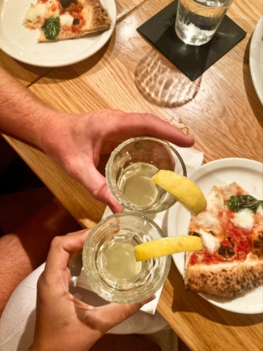 Two glasses of housemade limoncello and margherita pizza at Marco’s Coal Fired