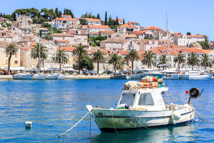A small boat floats in the water in Hvar harbor