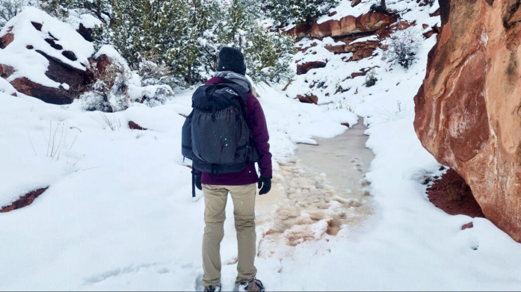 The author, Abigail, wearing the Hyperlite Mountain Gear Southwest Backpack on a hike in winter