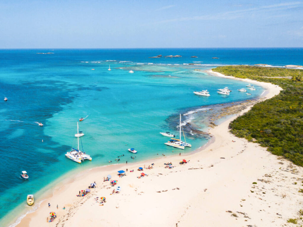 Aerial view of the beach goers and the catamaran along the coast in Icacos