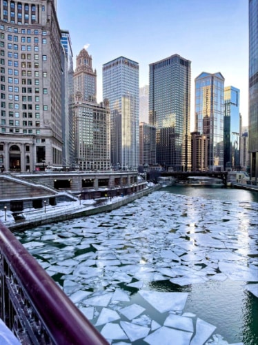 View of the ice-covered Chicago River and the city skyline in the background