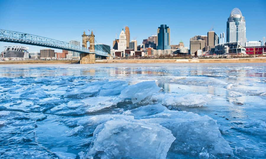 View of an icy Ohio River, Roebling Bridge, and Cincinnati's skyline during winter