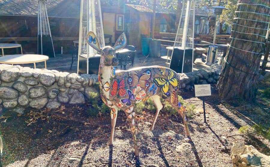 A sculpture of deer painted with colorful butterflies in Downtown Idyllwild