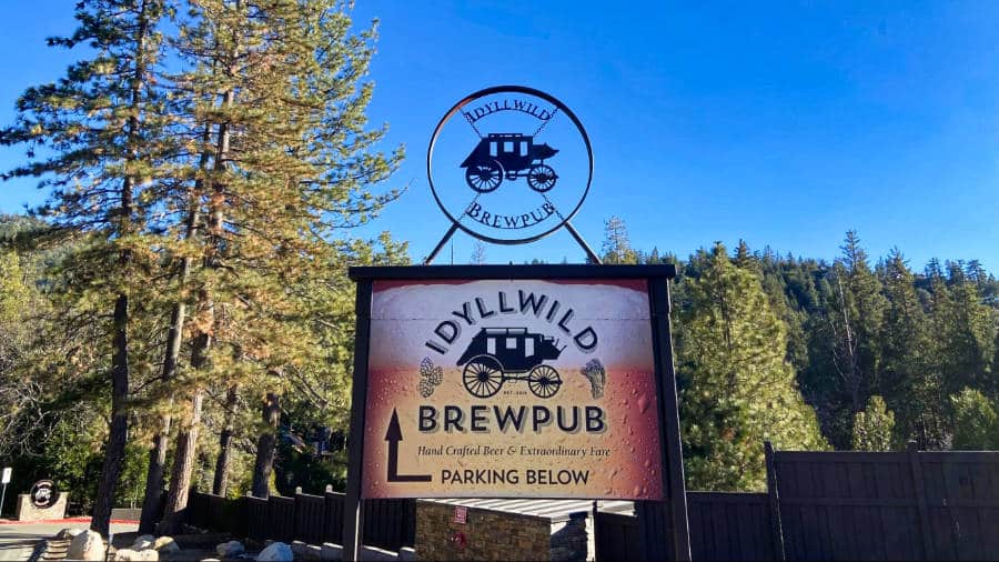 Signage of Idyllwild Brewpub parking area with a clear blue sky in the background