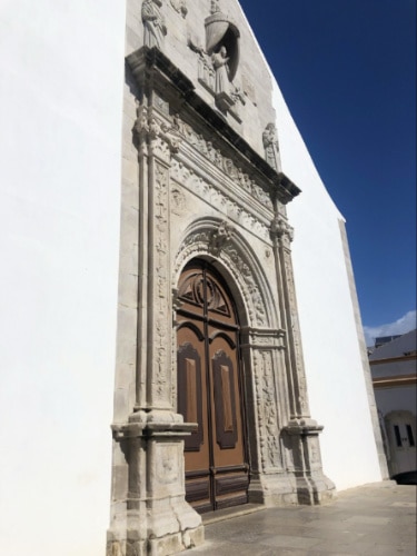 View of the intricately carved brown door and the entrance of Igreja da Misericórdia