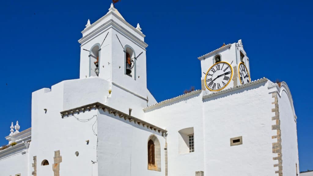 Exterior view of Santa Maria do Castelo church with a clear blue sky in the background in the old town of Tavira