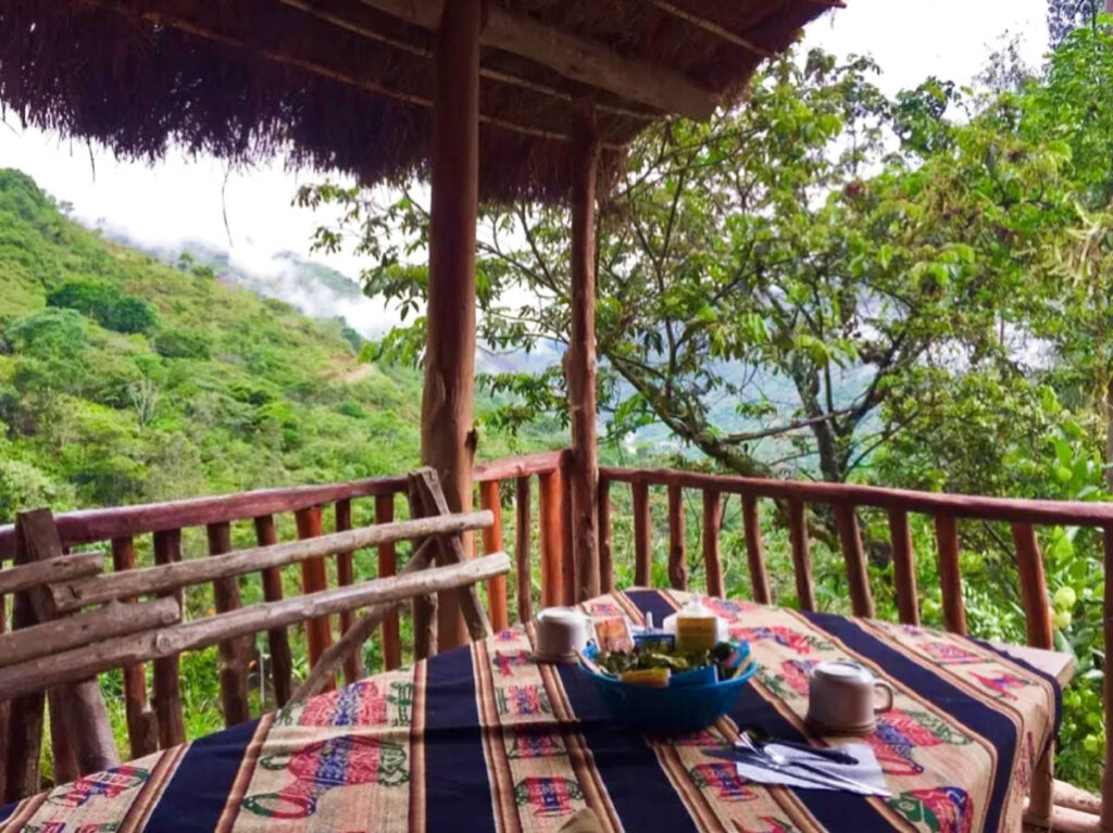 A breakfast table with an overlooking view of the lush mountain in Cusco