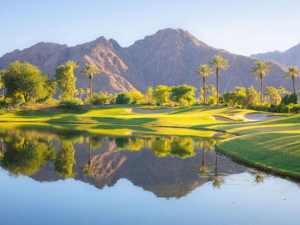 Golf course with palm trees and San Bernardino mountains in the background in Palm Springs