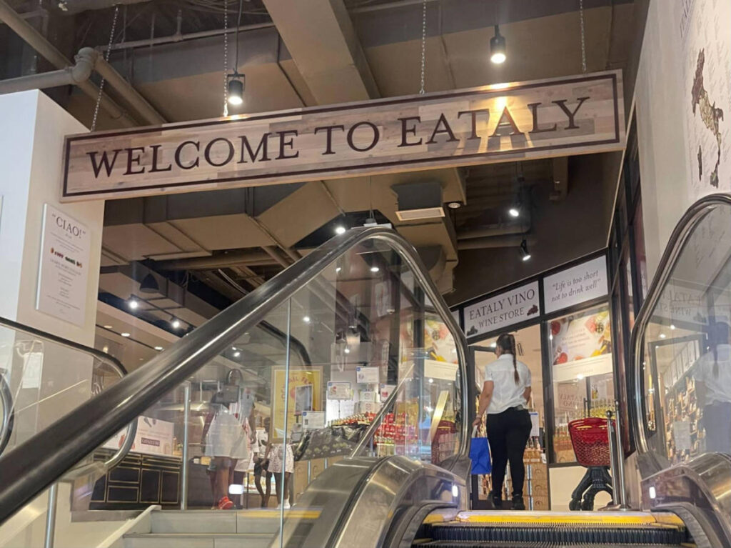 View of the welcome signage to Eataly market from the escalator