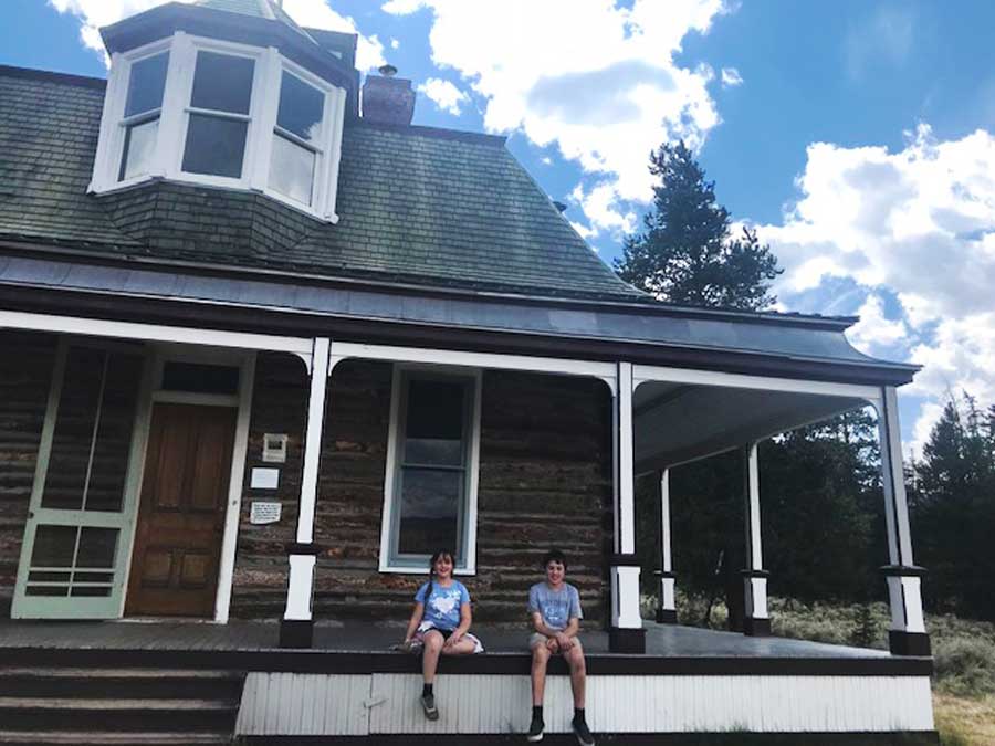 View of two kids sitting in front of an old resort in Interlaken