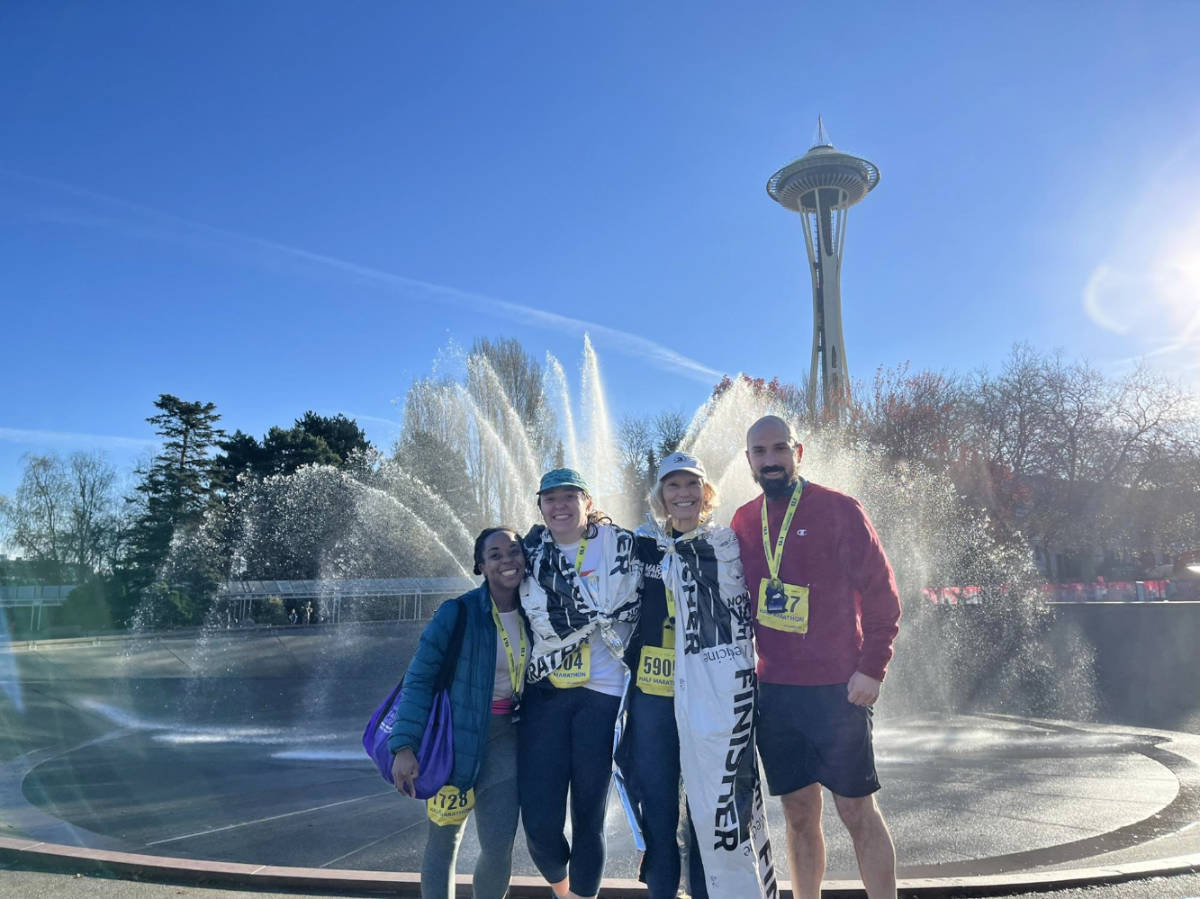 The author Chelsea Booker with her husband and in-laws with the International Fountain and Space Needle on their background