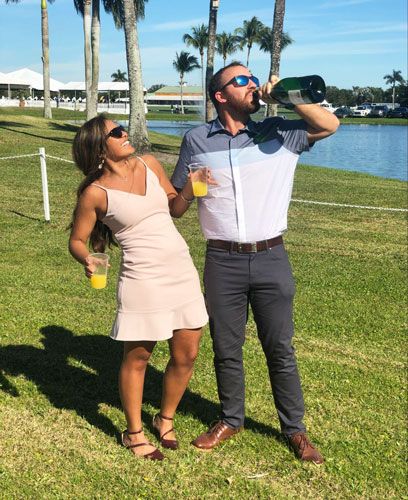 The author holding a bottle of champagne with his wife on his side in International Polo Club in Wellington
