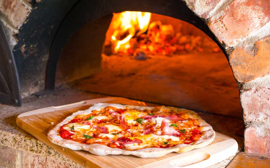 View of a pizza from a wood fired brick oven in Isola Pizza Bar