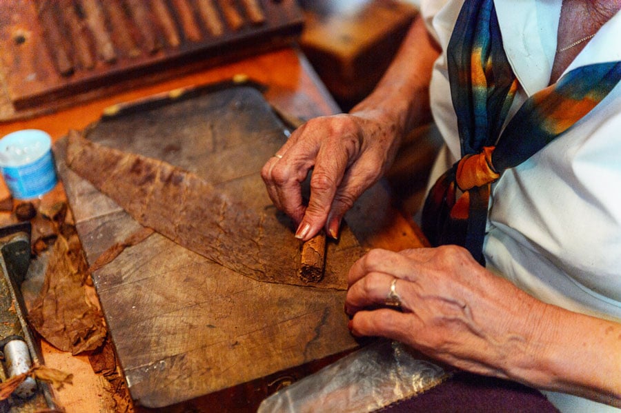 View of a woman manufacturing a Cuban cigars through rolling process