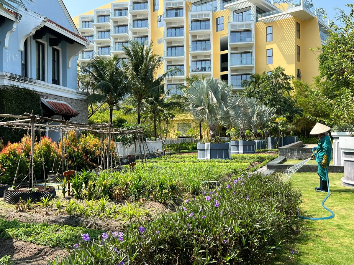 A worker watering the plants at the JW Garden