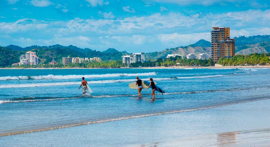 View of surfers having fun in Jacó Beach