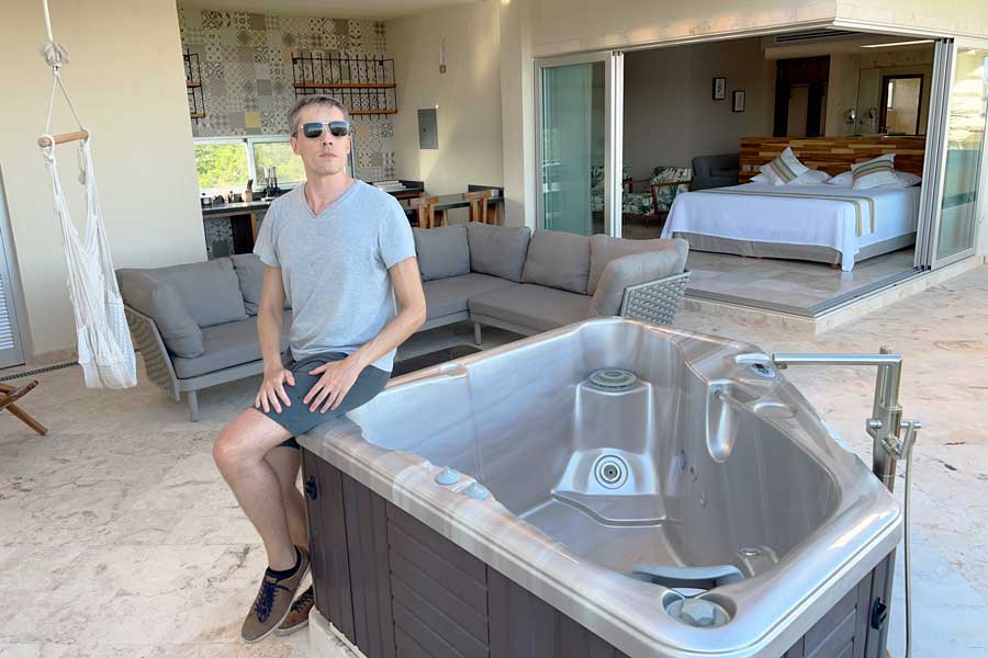 Nate sitting on the side of a jacuzzi in Valhalla Residences by Biwa