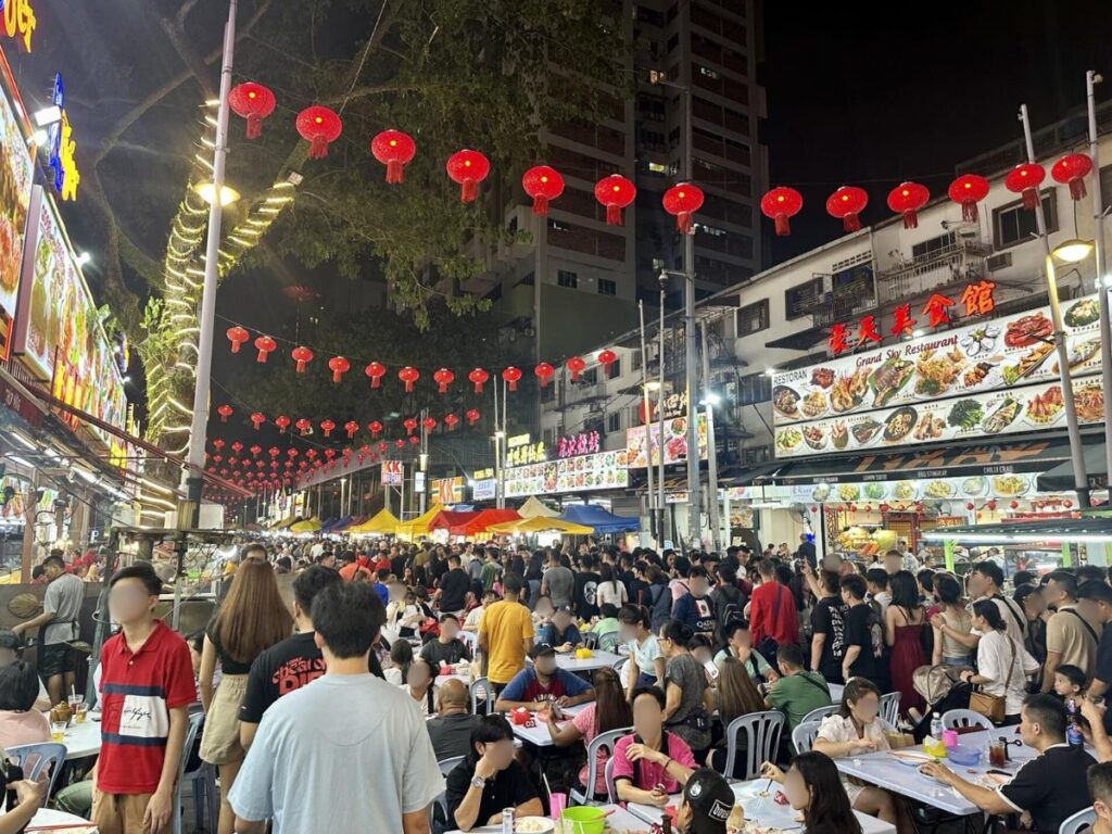 View of people eating street foods and walking along the Jalan Alor street