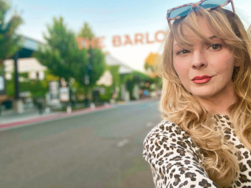 The author Jericha Griffin posing for a photo with The Barlow signage in the background