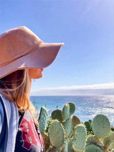 The author Jericha Griffin enjoys the scenic view of the beach with cacti around