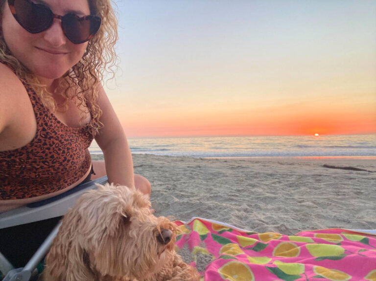 The author Jess and her dog enjoying the sunset views at the beach