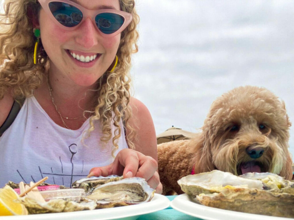 Travel Lemming writer Jess Levy enjoying the oysters with her dog