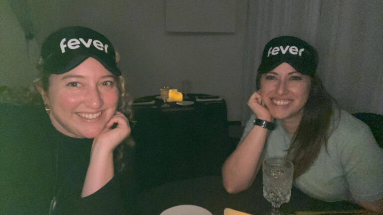 The author Jess Levy and her friend smiling for a photo while in the dark