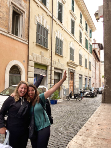 The author Jess and her friend posing for a photo at the cobblestone street in Rome
