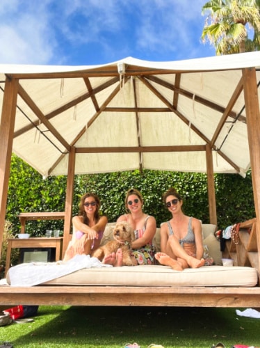 The author Jess Levy, chilling with her dog and friends on a day bed in Mission Estancia Pool Day
