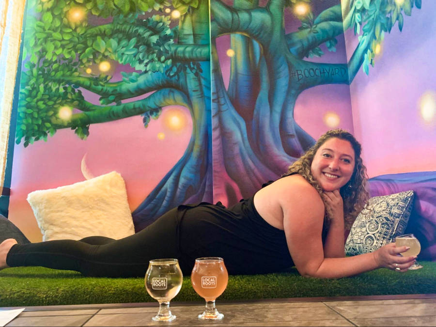 The author, Jess in a yoga class at Local Roots Kombucha with glasses of drinks