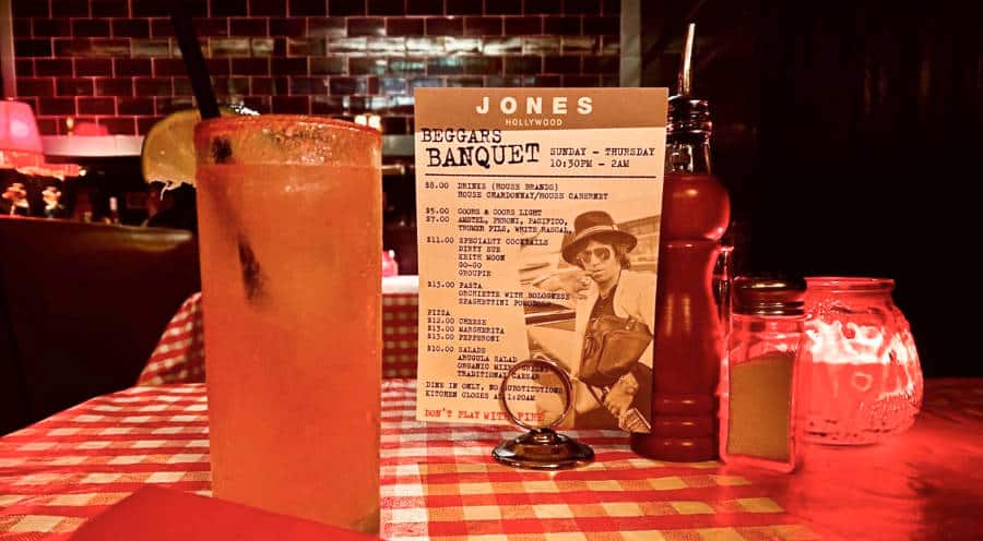 A glass of drink with a sliced lemon on the table of the dimmed restaurant of Jones Hollywood