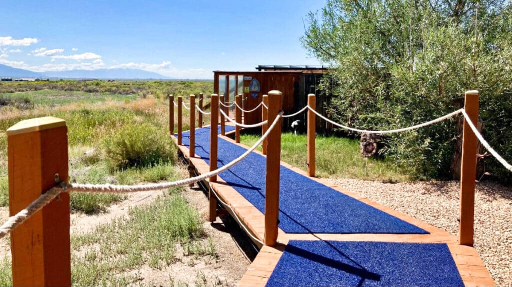 View of the blue boardwalk leading to Joyful Journey Hot Springs