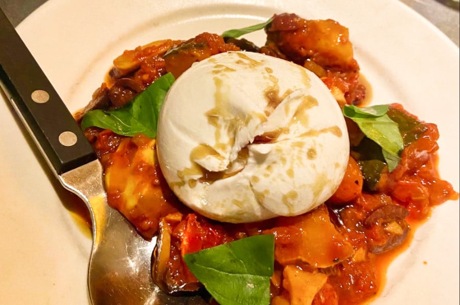 A closeup look at a Juicy burrata on a bed of pumpkin caponata at Elliot’s Borough Market