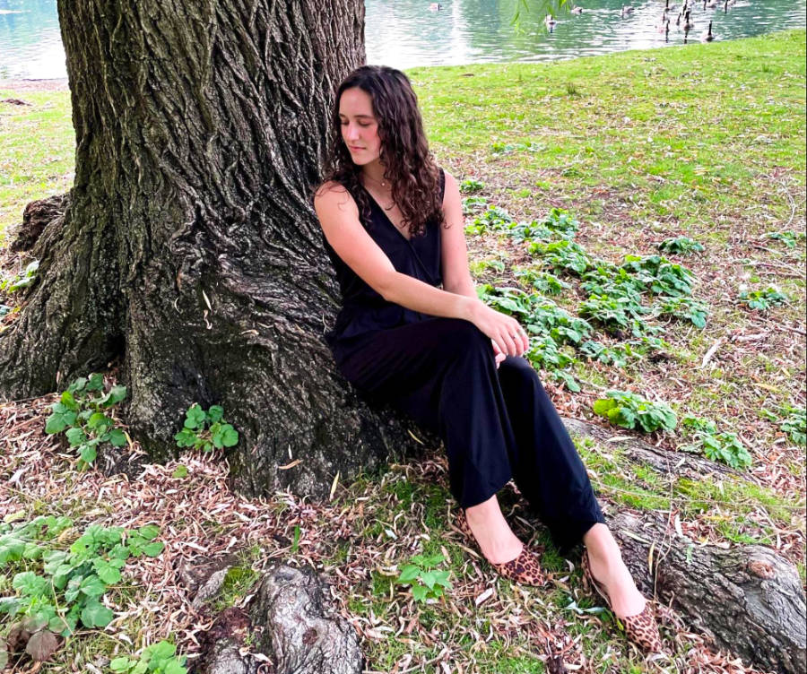 The author Taylor Ramsey sitting on a big root of a tree near the pond at Julia Davis Park