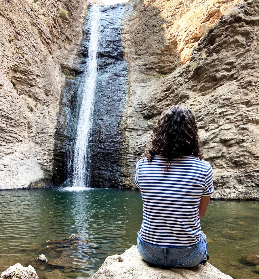 The author (Taylor Ramsey) watching the stunning view of the waterfall while sitting on a rock in Jump Creek Falls
