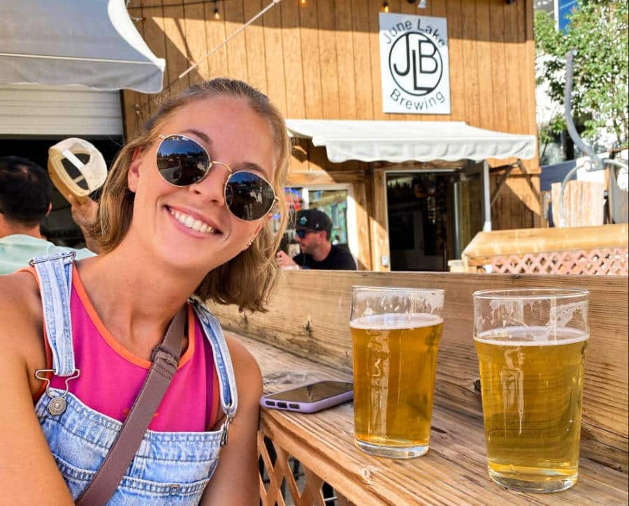 The author (Ashleigh Bandimere) with two glasses of beer in June Lake Brewing.