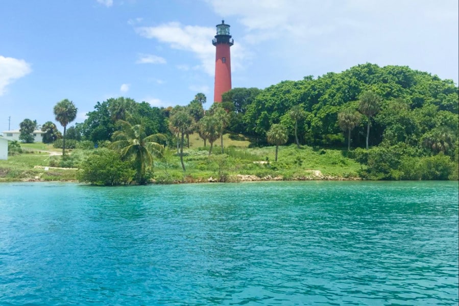 View of lighthouse at Jupiter with water in foreground
