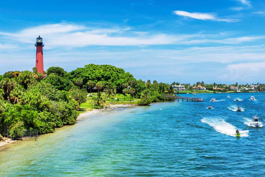 Aerial view of the lighthouse in Jupiter and boats on the clear blue water