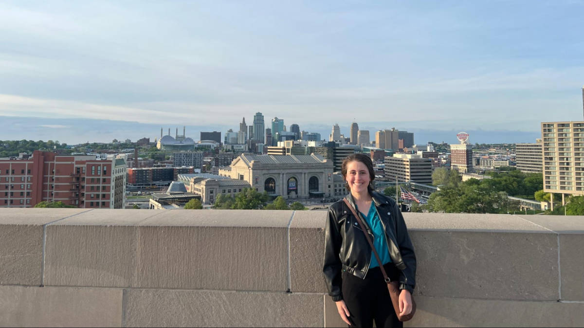 The author Kara Walters posing for a photo with an overlooking view of Kansas City skyline