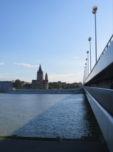 A bridge over a river with Katholische Kirche St. Franziskus von Assisi in the background