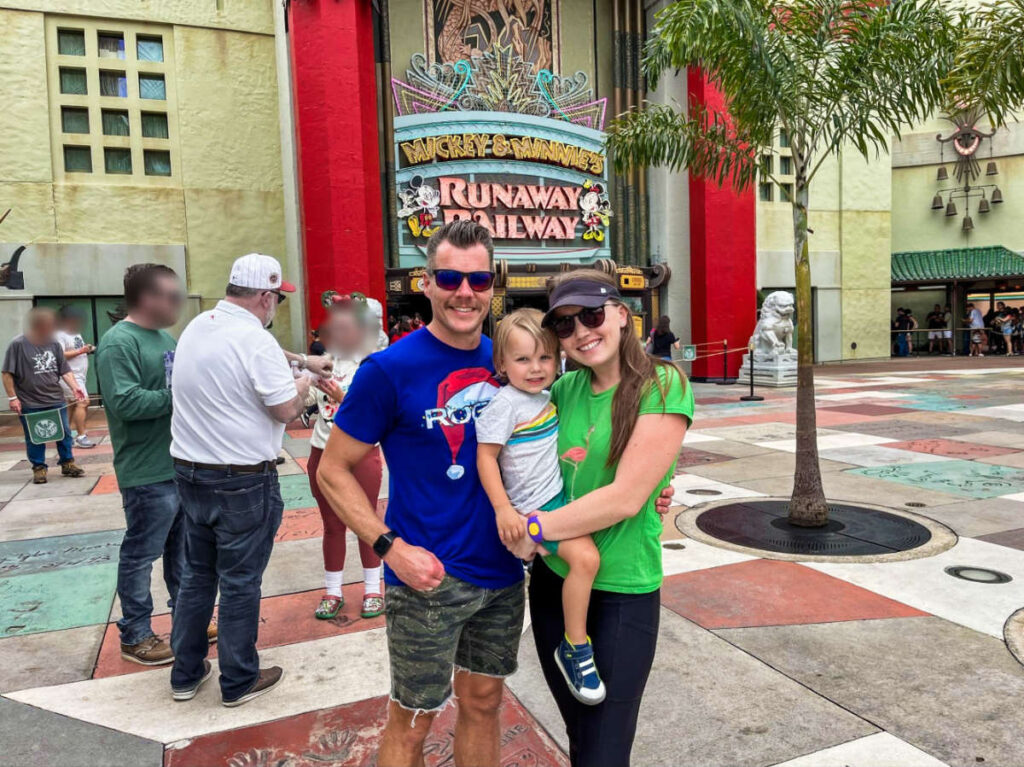 The author Katie Neufeld and her family, posing for a photo in front of the Mickey & Minnie’s Runaway Railway
