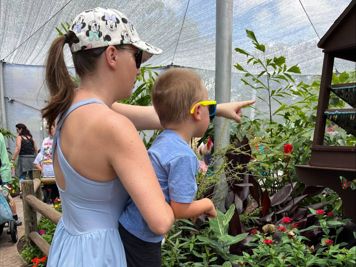 Katie showing the flowers to her son at Epcot International Flower and Garden Festival
