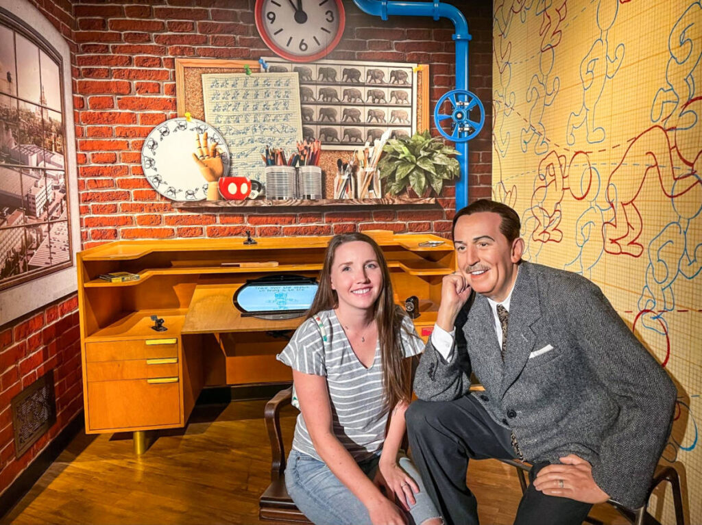 The author Katie Neufeld, posing for a photo with the wax figure of Walt Disney